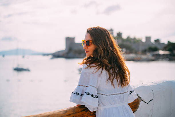 istock Beautiful Woman Watching Sea View From Terrace 1388542382