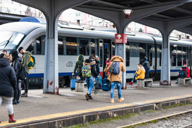 viaggiatori e pendolari in attesa di un treno sulla piattaforma ferroviaria della stazione ferroviaria di bucarest nord (gara de nord bucharest) a bucarest, romania, 2022 - cfr foto e immagini stock