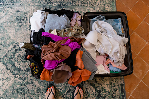 An aerial view of a messy case that is laid open on the floor in a bedroom of a holiday home in Toulouse in the south of France.