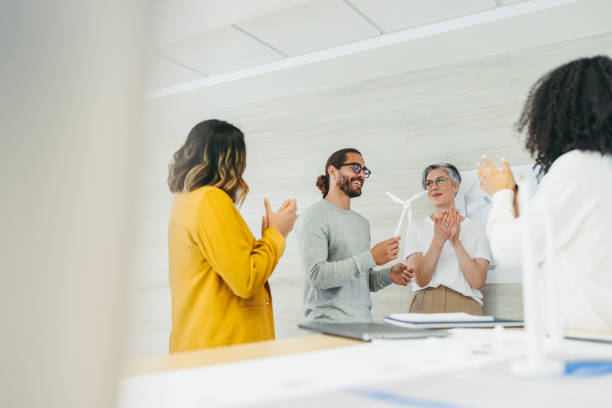 istock Successful designers applauding their colleague in an office 1388546222