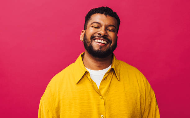 istock Happy young man smiling cheerfully with his eyes closed 1388547240