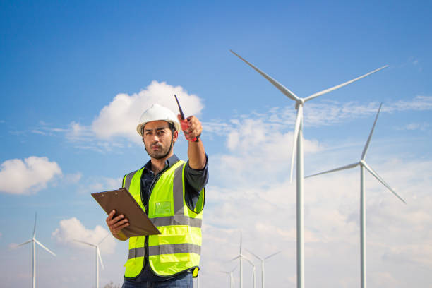 istock engineer team working in wind turbine farm. Renewable energy with wind generator by alternative energy concept. 1388547539