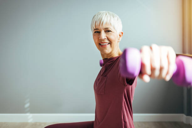 istock Mature beautiful woman does exercises with dumbbells 1388547655
