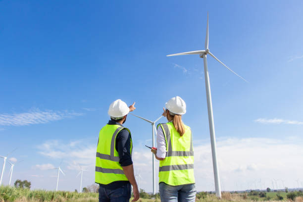 istock engineer team working in wind turbine farm. Renewable energy with wind generator by alternative energy concept. 1388547711