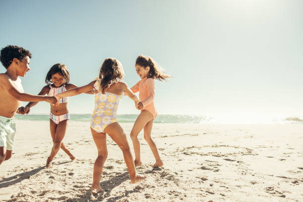 istock Energetic little kids playing a game together at the beach 1388547780
