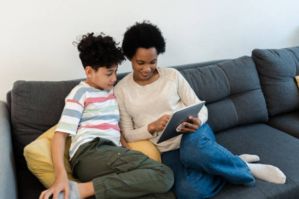 istock African American woman enjoying with her son at home and using tablet 1388551148