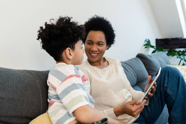 istock African American woman and her son relaxing on the sofa and using tablet 1388551152