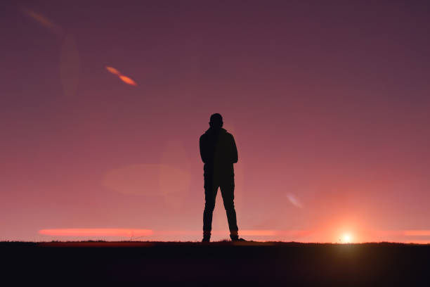 istock man silhouette in the mountain with a beautiful sunset background 1388551442
