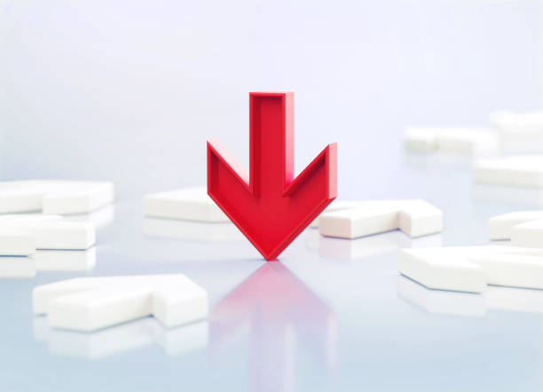Red down arrow sitting amid white arrows on white reflective background. Horizontal composition with copy space.