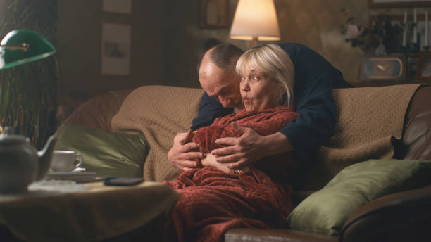 istock Senior man hugging surprised woman on couch 1388559063