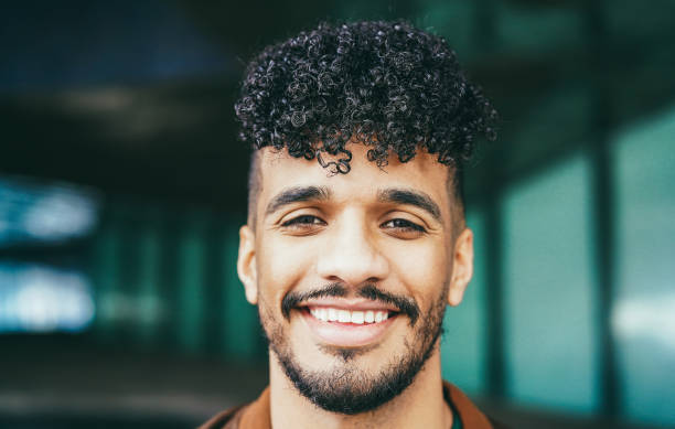 istock Young latin man smiling on camera outdoor - Focus on face 1388559179