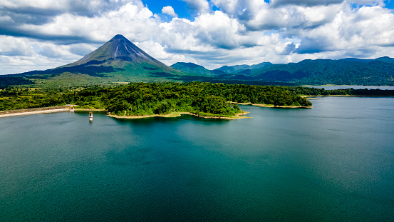Arenal Volcano National Park in Costa Rica with Arenal Lake.  The volcano is surrounded by lush tropical rainforest.