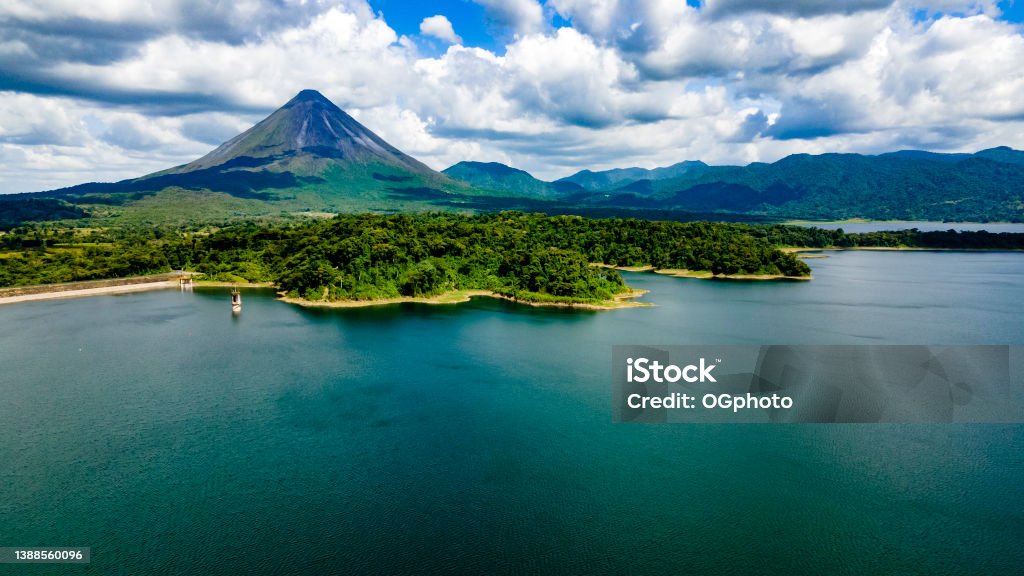 Arenal Volcano and Arenal Lake, Costa Rica Arenal Volcano National Park in Costa Rica with Arenal Lake.  The volcano is surrounded by lush tropical rainforest. Costa Rica Stock Photo