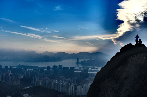 Hikers enjoying Hong Kong cityscape at sunset on Kowloon Peak (Fei Ngo Shan), a mountain height 602 mt located in New Kowloon, Hong Kong.