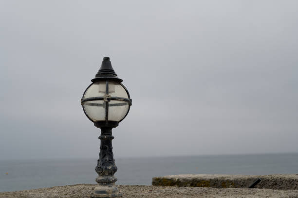 Old Victorian street lamp with the view of the English coast in the background