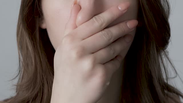 young woman closes nose because of a bad smell