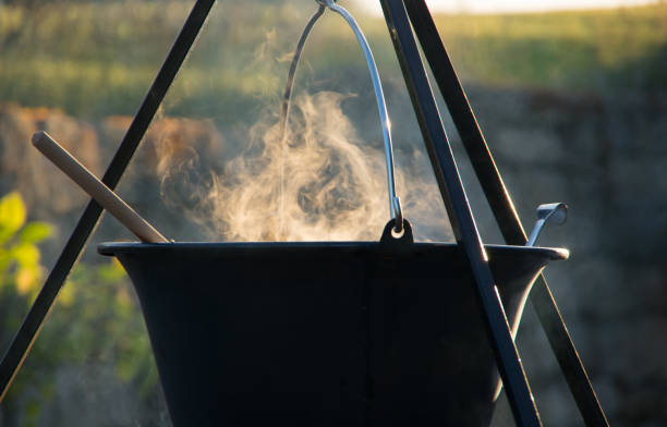 istock Steaming kettle over the campfire, Cooking in the kettle over the fire bowl 1388562124