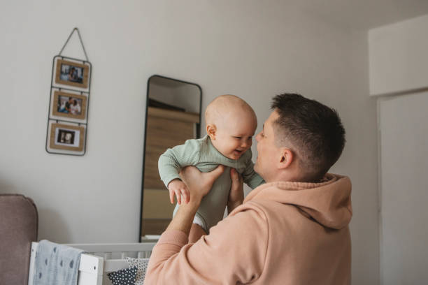 istock Father and baby playing on bed 1388564256