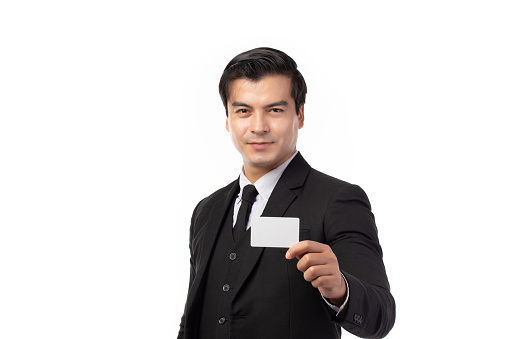Handsome business man in black suit holding credit card isolated on white background. Business, technology, ecommerce and online payment concept.