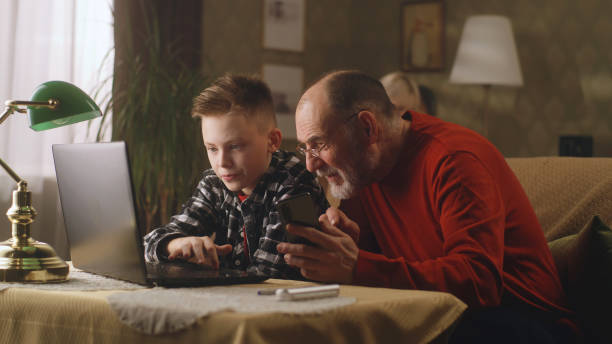 istock Grandson helping granddad to use devices 1388567819
