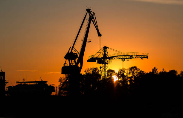 istock River boat and floating river cranes on the river bank at sunset. 1388569517