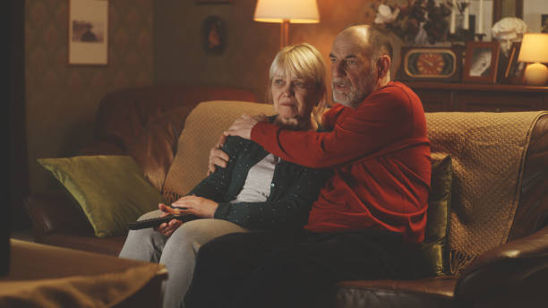 istock Aged couple watching thriller at home 1388569766