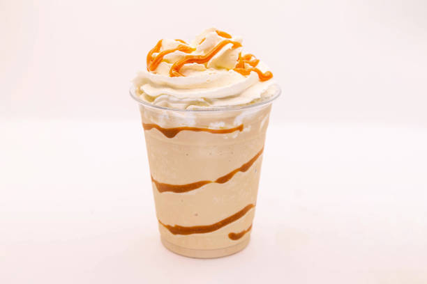 caramel flavoured frappe served in a plastic cup with whipped cream and dressing. - caramel latté coffee cafe macchiato imagens e fotografias de stock