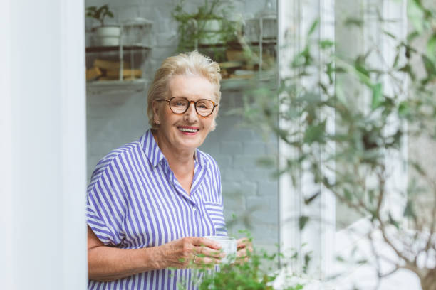 istock Happy senior woman having coffee at home 1388569848