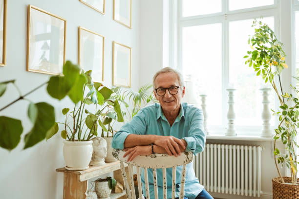 istock Senior man sitting on chair at apartment 1388570021
