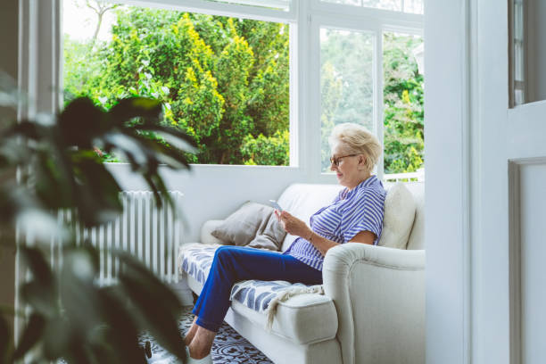 senior woman using tablet pc at home - 銀髮族網民 個照片及圖片檔