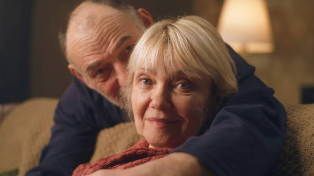 istock Elderly husband hugging wife on sofa 1388571710