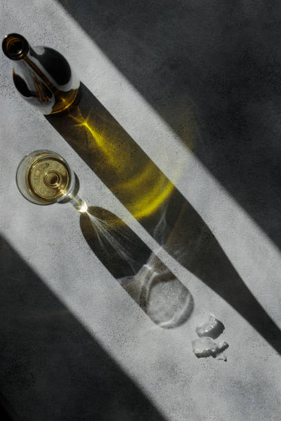 istock Glass of wine with shadows on a gray concrete table 1388573824