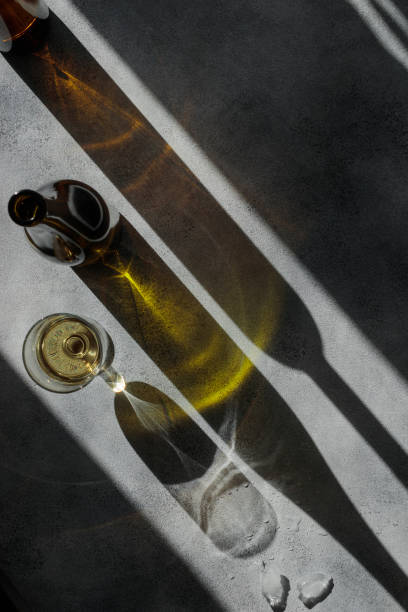 istock Glass of wine with shadows on a gray concrete table 1388574496