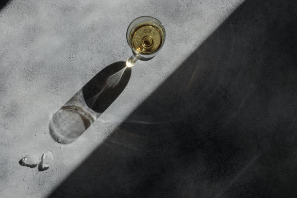 istock Glass of wine with shadows on a gray concrete table 1388574631