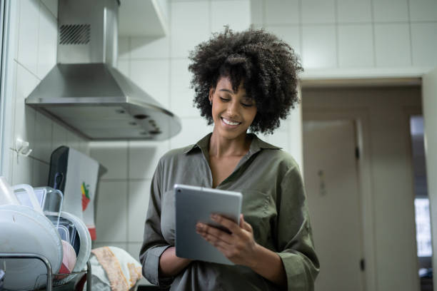istock Portrait of woman using tablet in the kitchen 1388575874