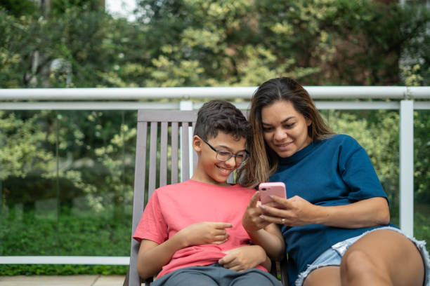 istock Mother and son using cellphone at hotel 1388575919