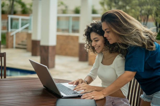 istock Mother and daughter using laptop in hotel 1388575947