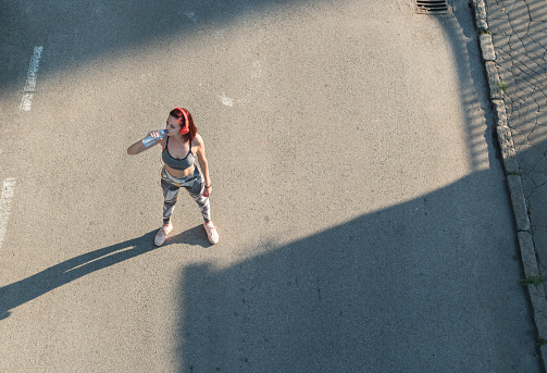 Top view woman drinking from water bottle