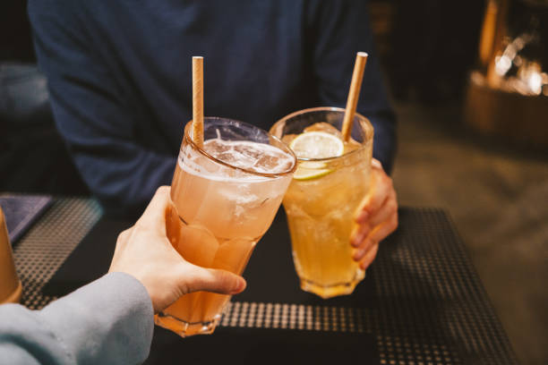 duas pessoas irreconhecíveis brindando com coquetéis no bar - refreshment drink drinking straw cocktail - fotografias e filmes do acervo