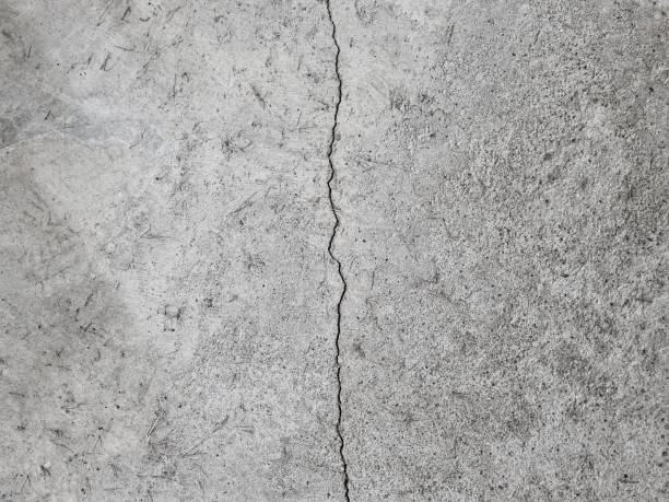 grieta en un piso de concreto gris, pared, superficie, textura gris - crevice fotografías e imágenes de stock