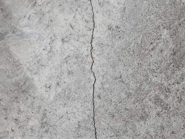 Crack on a grey concrete floor, wall, surface, grey texture