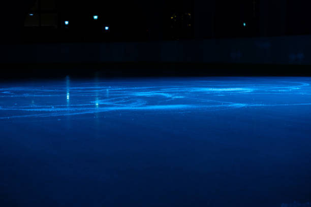 Joyful couple having a great time ice skating in the skate ring on a winter holiday.