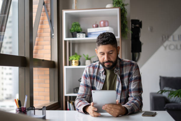 istock Portrait of man using tablet at home 1388580866