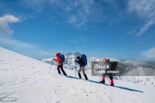 Successful Mountain Climber Team Is Climbing In A Row On The Ridge Of The High Altitude Snowy Mountain Summit In Winter Stock Photo - Download Image Now