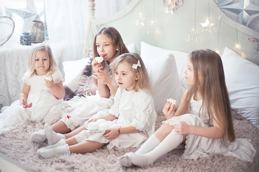 Girls sisters or friends eat sweets in the morning in the bedroom. Winter holidays.