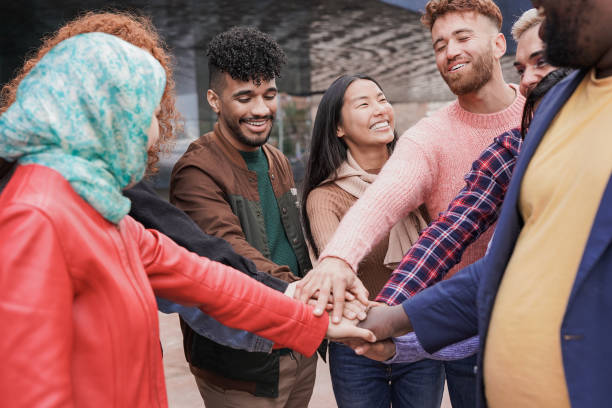 istock Group of young multiracial people stacking hands together outdoor 1388584197