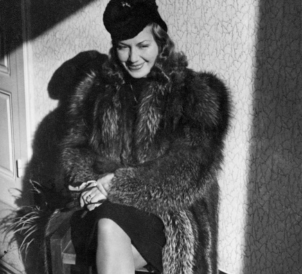 Beautiful Young Woman wearing fur in living room, 1938.