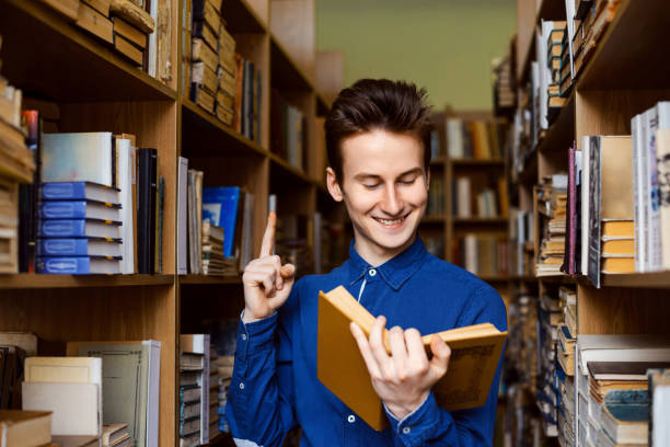 istock Happy student found necessary information in the book in library 1388584425