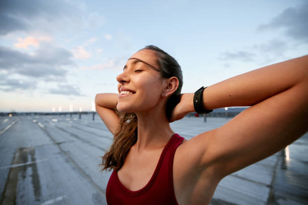 foto de una mujer joven tomando un descanso mientras hacía ejercicio al aire libre - women solitude enjoyment 20s fotografías e imágenes de stock