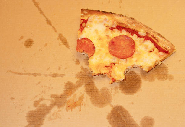 istock The remains of half-eaten pizza on a greasy box. Flat lay 1388586036